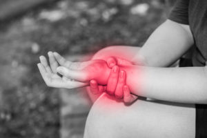 woman holding wrist due to injury