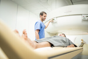 radiologist tech performing imaging scan on middle aged patient