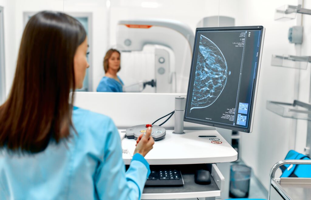 A patient getting a mammogram and doctor looking at the results.