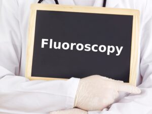 provider holding a sign that reads fluoroscopy.